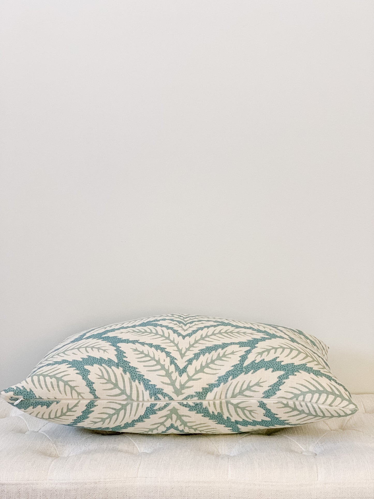 Side view of designer lumbar pillow with palm motif in aqua and cream tones. Large scale geometric.