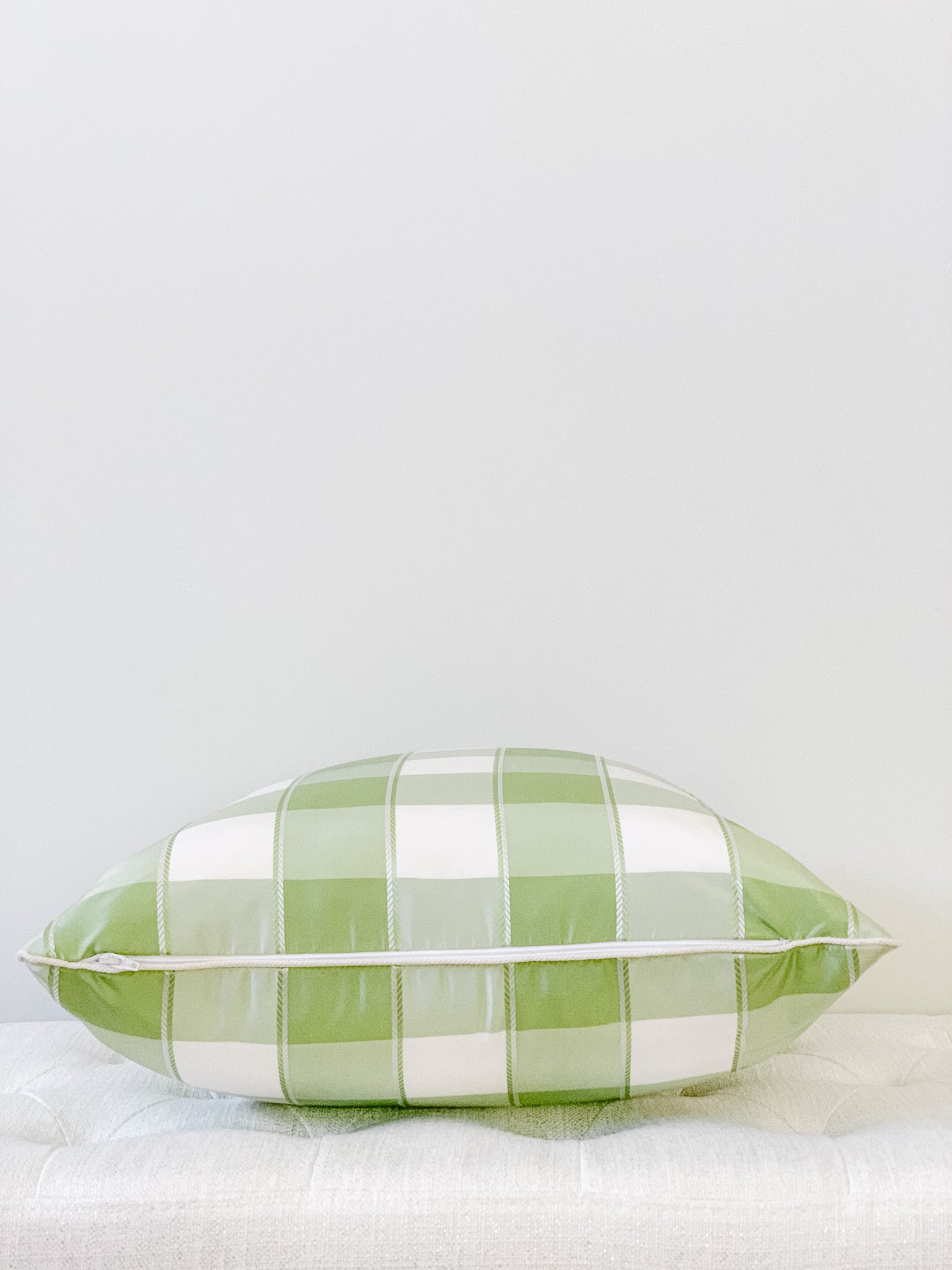 Side view of green and white plaid silk pillow with zipper closure.