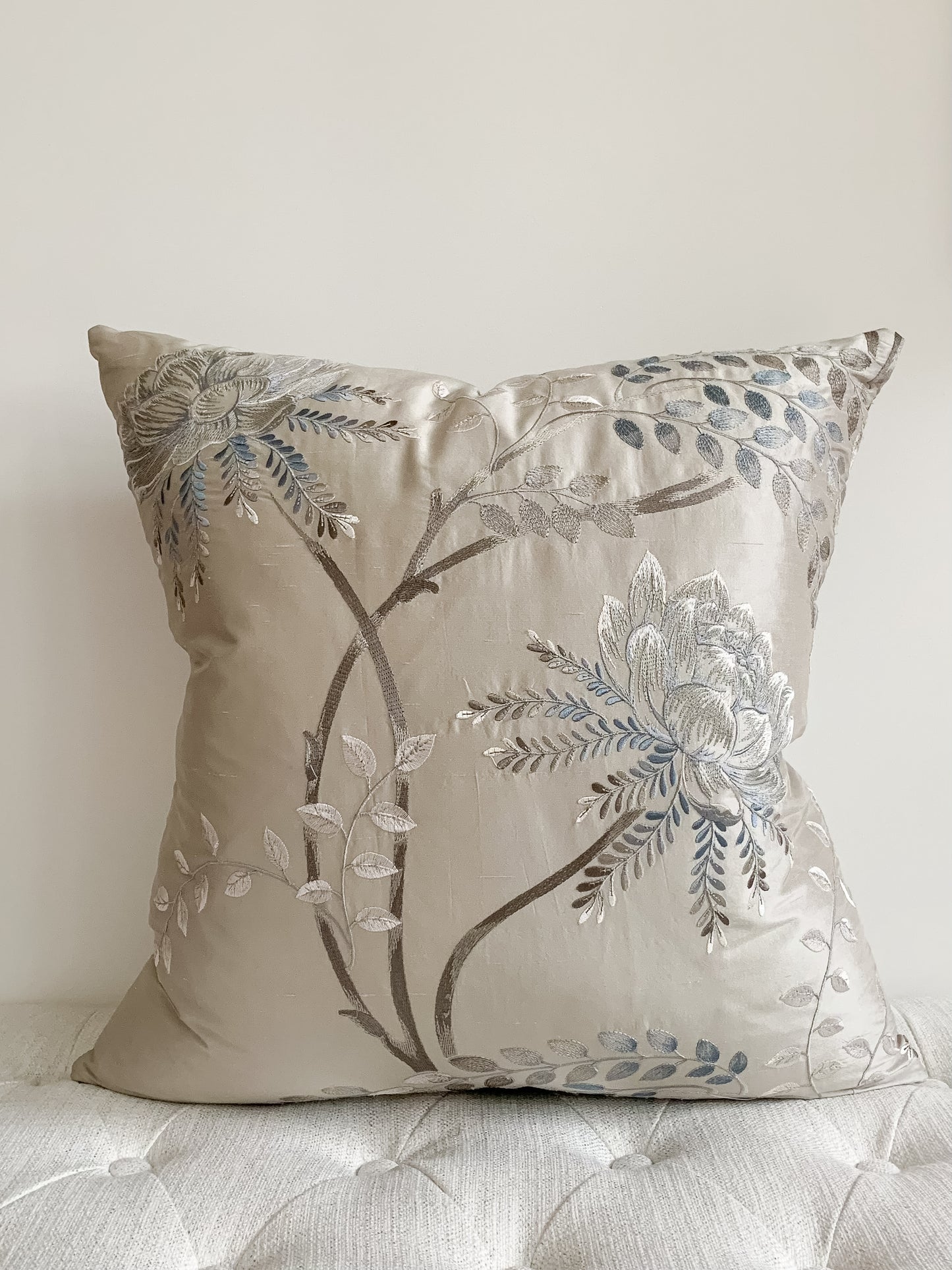 Silk designer accent pillow with flowers and branches.  Light blue petals and leaves on a shimmery taupe background