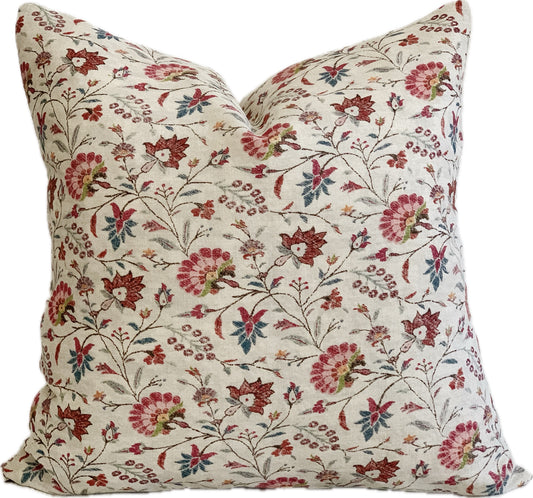 Small scale botanical designer pillow cover with blush pink, cranberry and blue flowers against a beige linen background.  Pillow is a 22" x 22" square