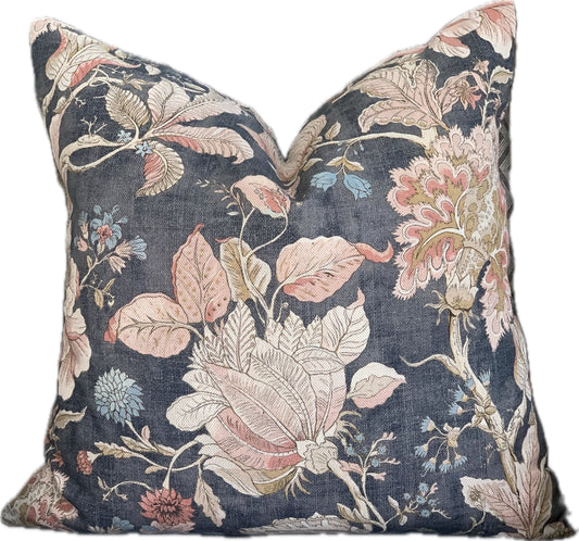 Square designer throw  pillow with large flowers and leaves in blush pink and beige on a dark blue background.