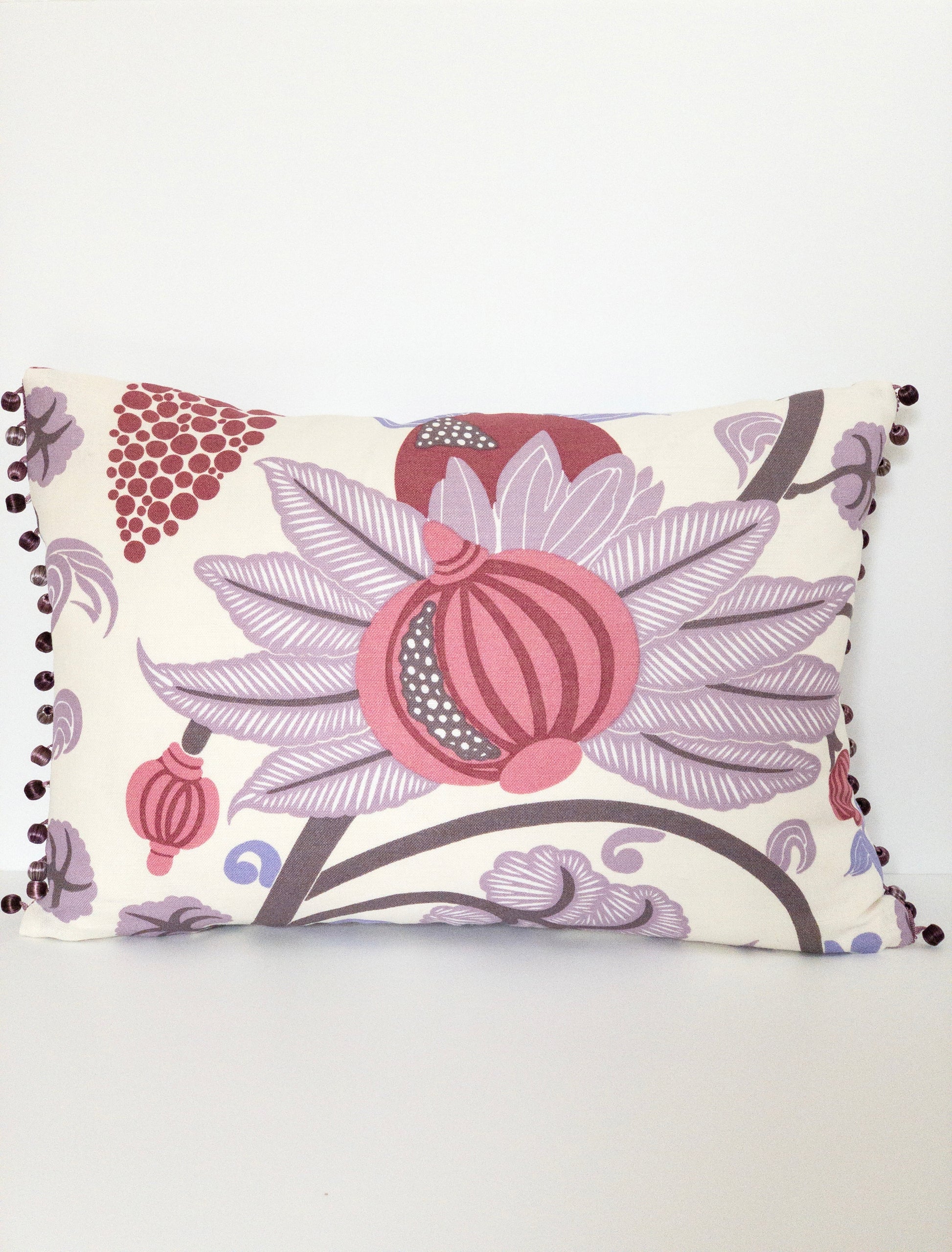 Colorful raspberry and purple floral motif pillow with purple beaded trim