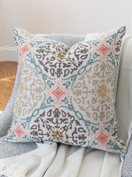 Designer accent pillow with brown and gold medallions and coral and teal motif