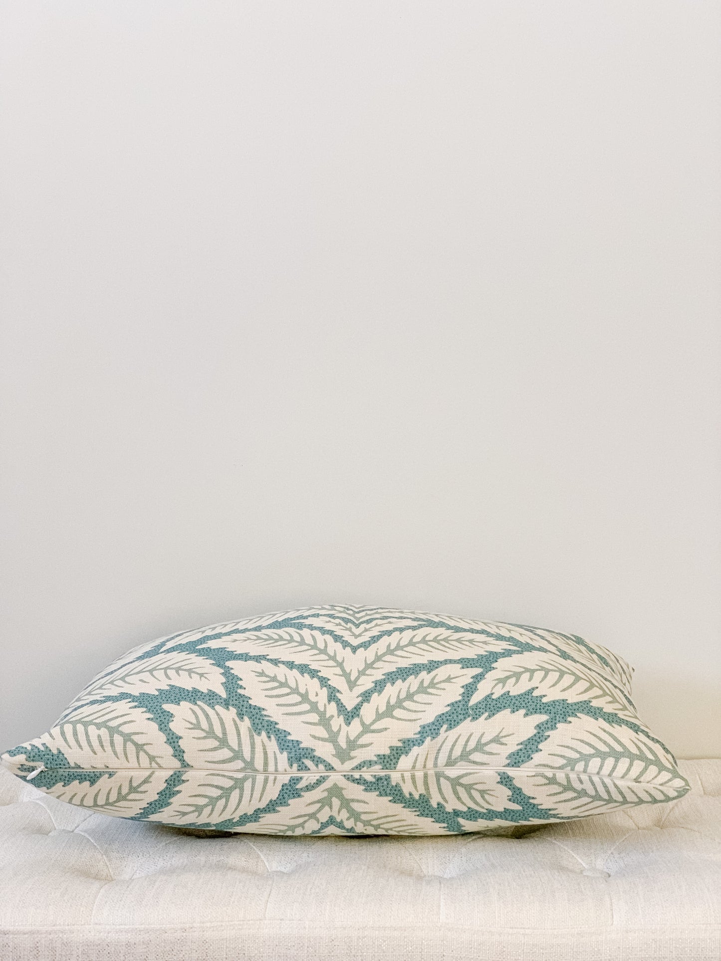 Side view of designer lumbar pillow with palm motif in aqua and cream tones. Large scale geometric.