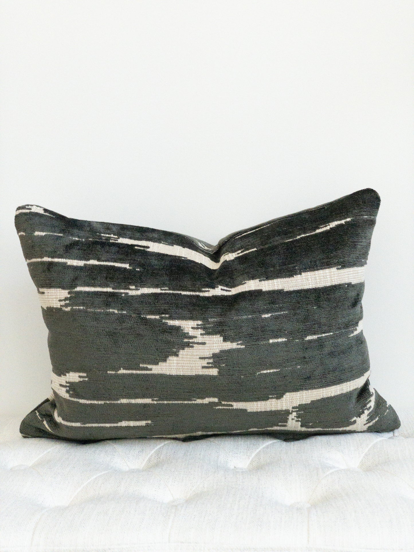 Black and beige chenille lumbar pillow.  Black raised threads on flat beige background.  Abstract placement of alternating colors.